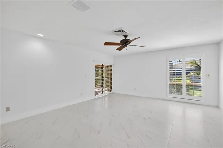 Spare room with light marble finish flooring and a ceiling fan