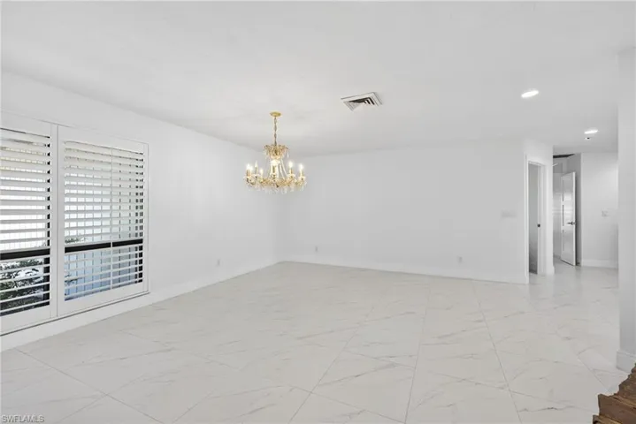 Empty room with suspended lighting and light marble finish flooring