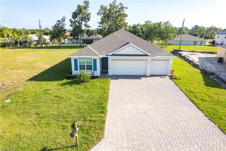 View of front of house featuring a front lawn and a garage