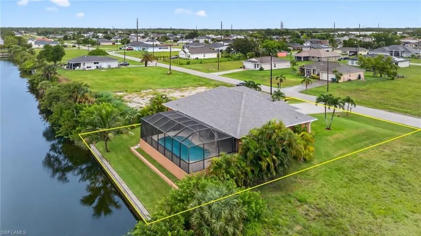 Aerial view of residential area featuring a large body of water and property boundaries highlighted