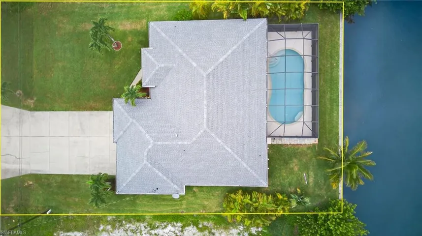 Aerial view of property and surrounding area featuring property parcel outlined and a pool area