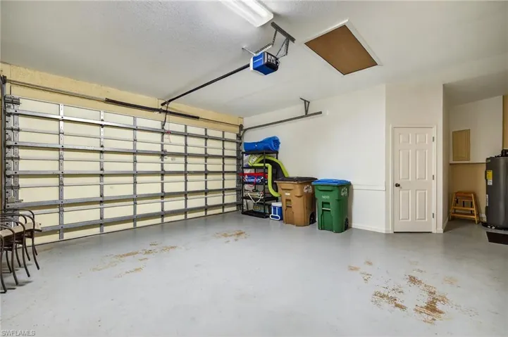 Garage featuring a garage door opener and water heater