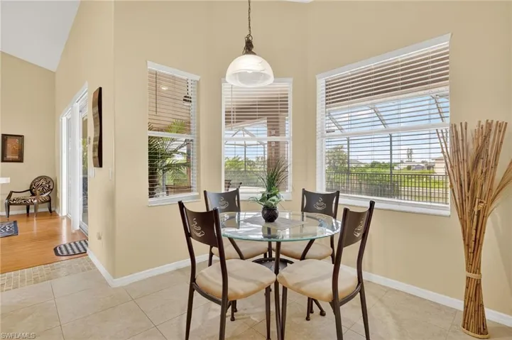 Dining space with high vaulted ceiling and light tile patterned flooring