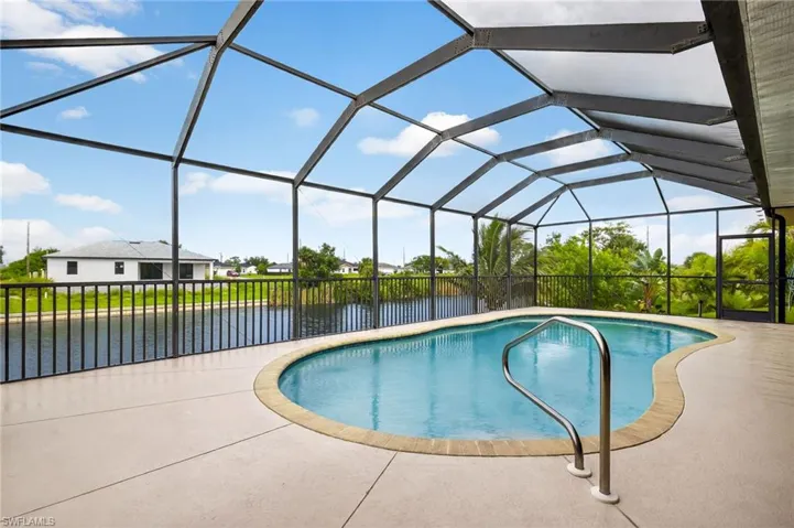 Outdoor pool featuring a water view and a patio area