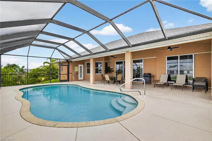 Outdoor pool featuring ceiling fan, a patio, glass enclosure, and outdoor dining area