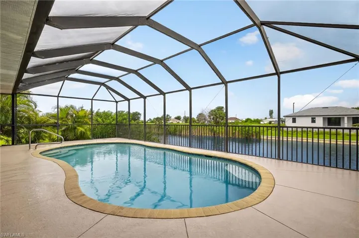 Outdoor pool with a water view, a patio area, and a lanai
