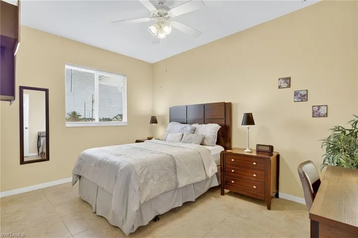 Bedroom featuring light tile patterned floors and ceiling fan