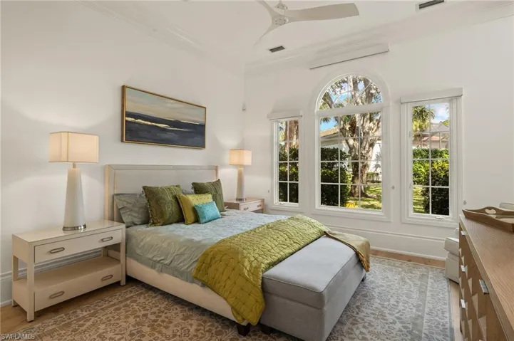 Bedroom featuring ornamental molding, light hardwood / wood-style floors, and ceiling fan