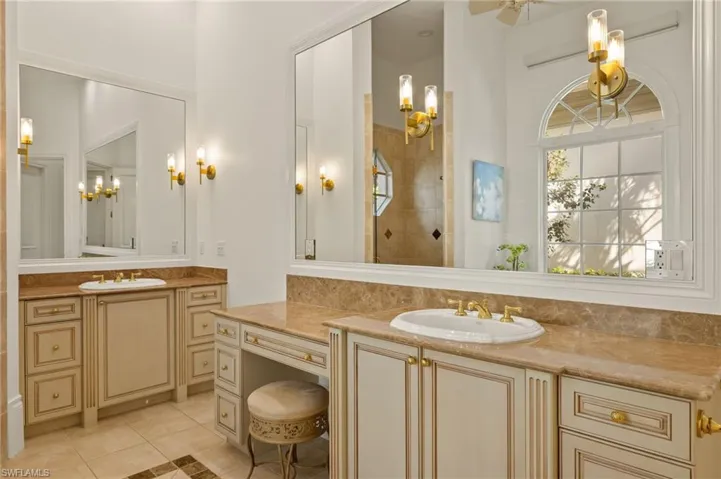 Bathroom with vanity, tiled shower, tile patterned floors, and ceiling fan