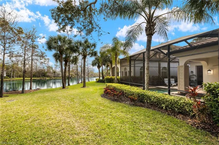 View of yard with a water view and glass enclosure