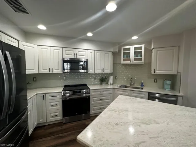 Kitchen featuring visible vents, a sink, white cabinets, and stainless steel appliances