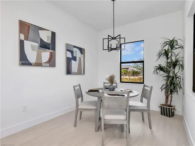 Dining area featuring light wood-finish flooring and a contemporary black geometric chandelier