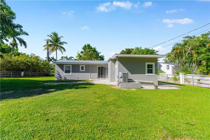 Rear view of house with a fenced backyard, stucco siding, and a patio area