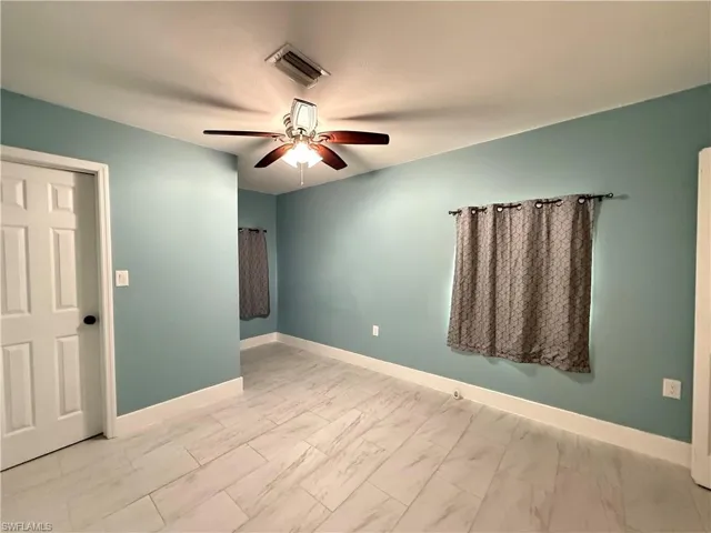 Unfurnished room featuring baseboards and ceiling fan