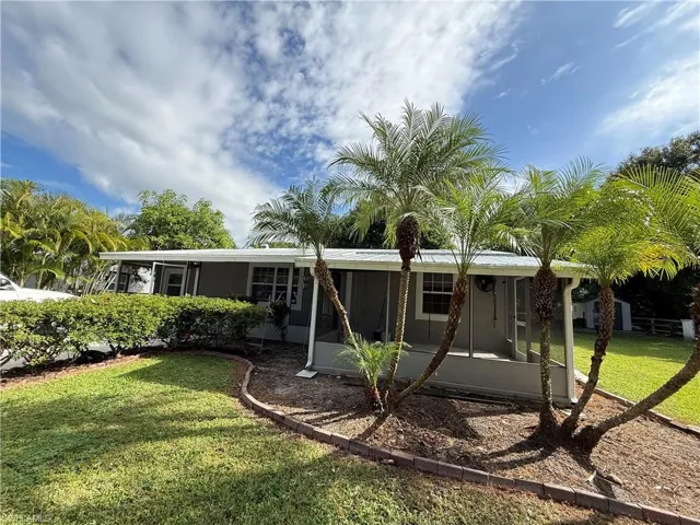 View of front facade featuring a front yard and a sunroom