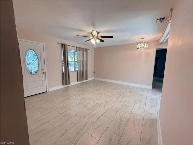 Foyer featuring a ceiling fan, a textured ceiling, and a chandelier