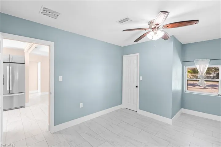 Unfurnished room featuring a ceiling fan and baseboards