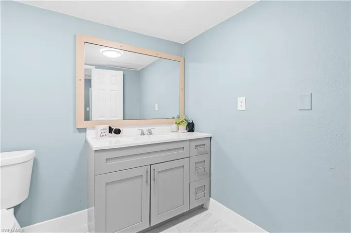 Bathroom with vanity and light marble finish flooring