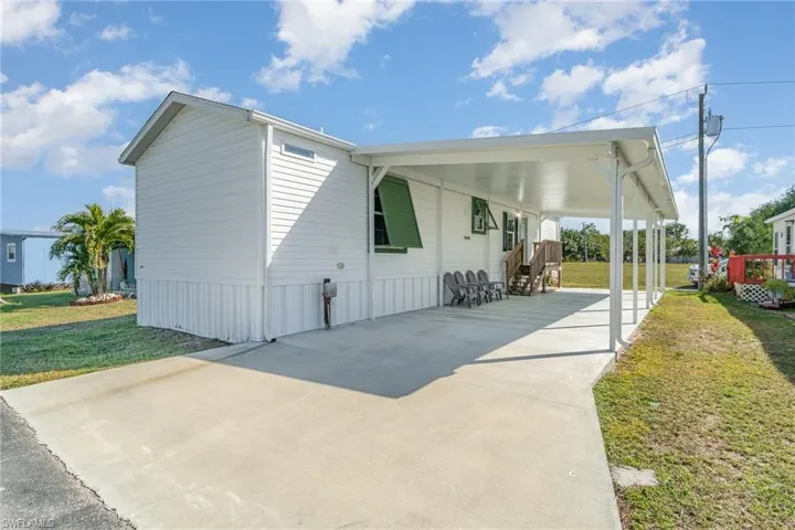 View of side of property with a carport and a yard