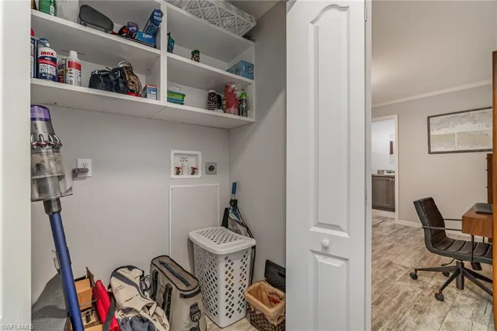 Laundry area featuring crown molding, hookup for a washing machine, light hardwood / wood-style flooring, and hookup for an electric dryer