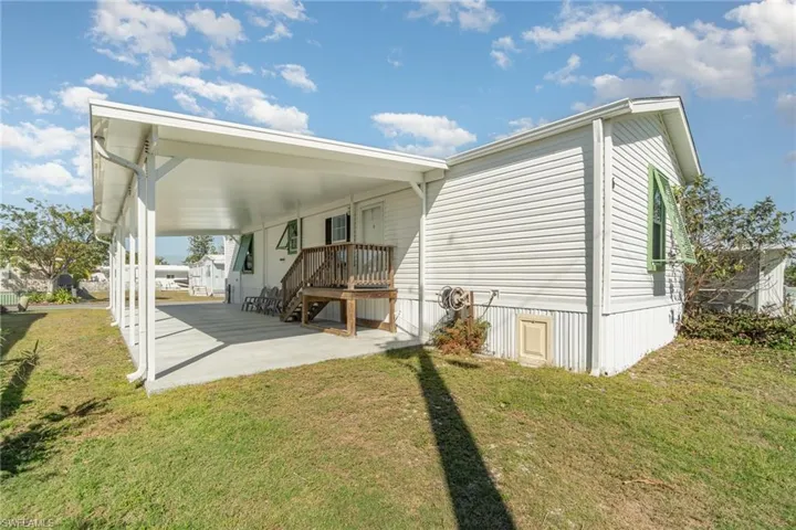 Rear view of house with a patio and a lawn