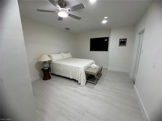 Bedroom featuring light wood-type flooring, a ceiling fan, and recessed lighting