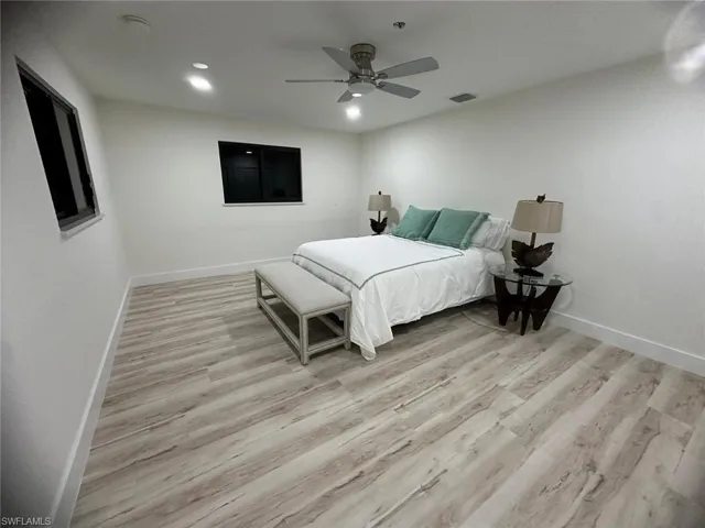 Bedroom with light wood finished floors, ceiling fan, and recessed lighting