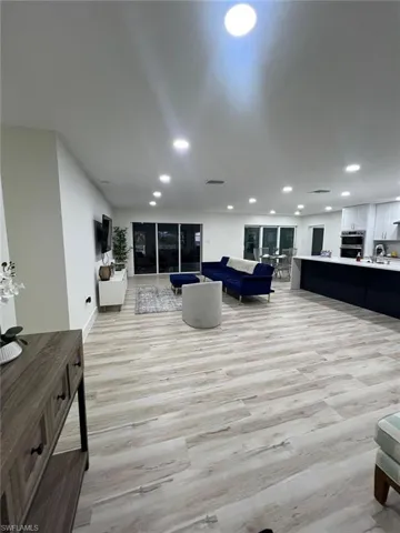 Living room featuring light wood finished floors and recessed lighting