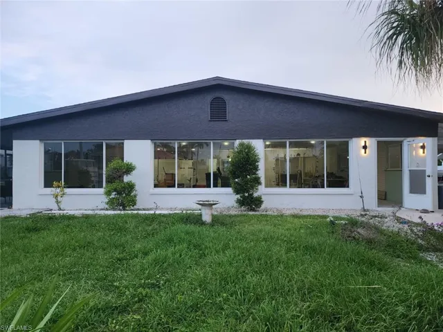 Back of house featuring a yard and stucco siding