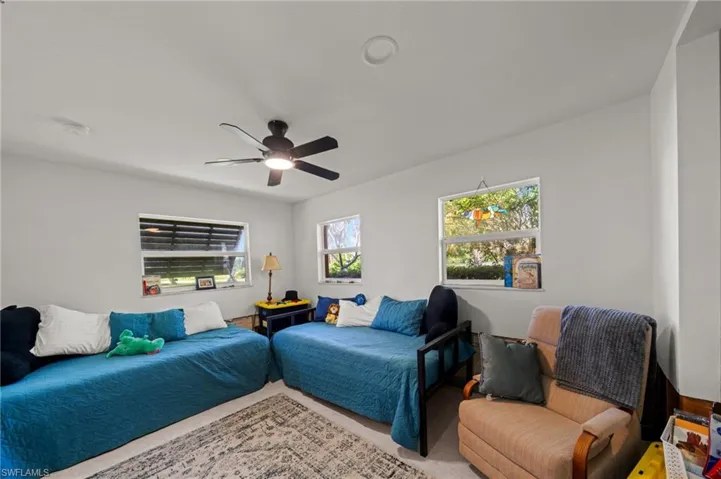 Carpeted bedroom featuring a ceiling fan
