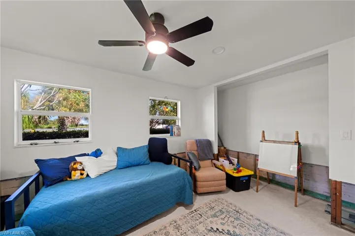 Carpeted bedroom featuring ceiling fan