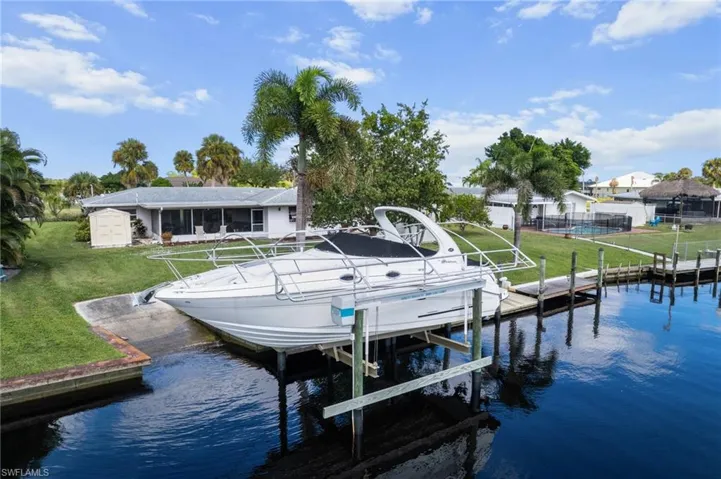 Dock with a yard, boat lift, and a water view
