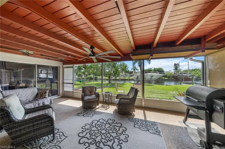 Sunroom with an outdoor hangout area, a water view, beam ceiling, and a ceiling fan