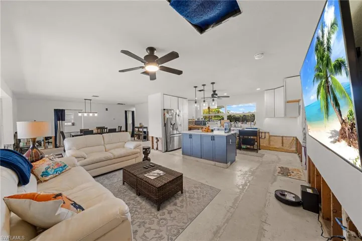 Living area featuring unfinished concrete floors and a ceiling fan