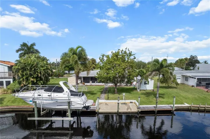 Dock with a lawn, a water view, and boat lift