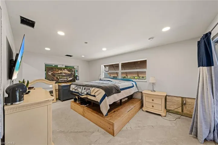 Bedroom with recessed lighting and concrete flooring