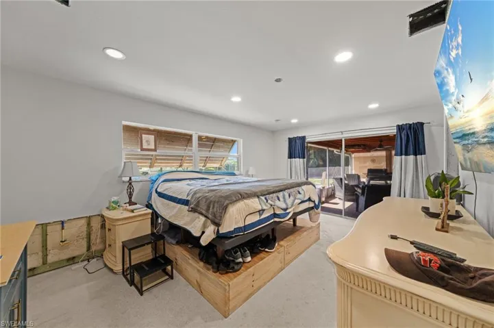 Bedroom with access to outside, recessed lighting, and finished concrete flooring