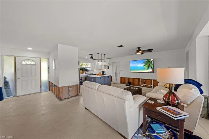 Living room featuring concrete flooring, plenty of natural light, and ceiling fan