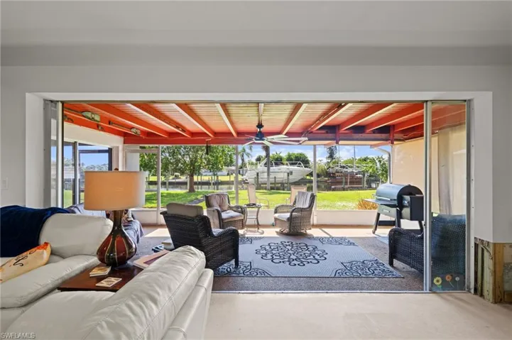 Living area with beam ceiling, healthy amount of natural light, and ceiling fan