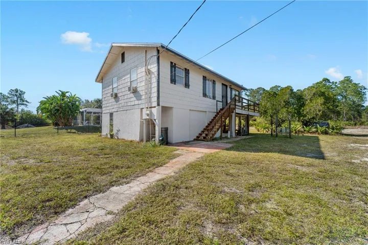 View of side of home with a yard and a deck