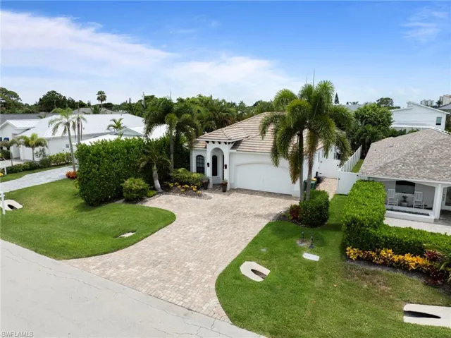 Mediterranean-style residence featuring a tile roof, arched entryway, and a paver driveway