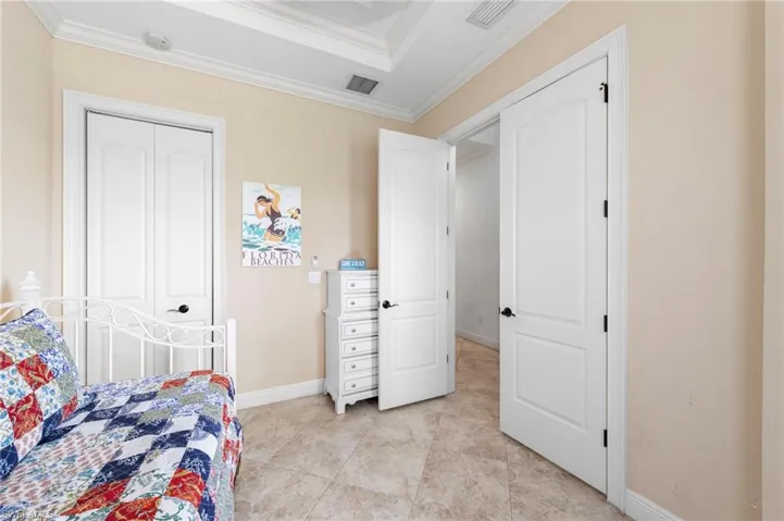Room featuring a tray ceiling, crown molding, and neutral wall tones