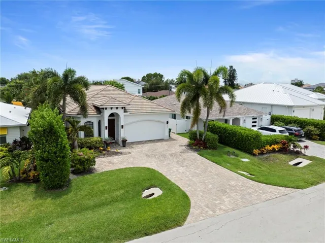Mediterranean-style residence featuring a barrel tile roof and an arched entry