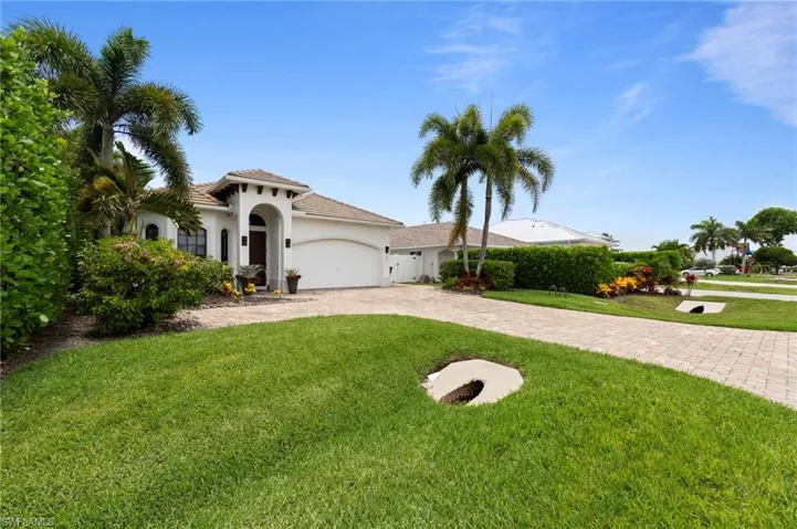 Mediterranean-inspired exterior with a barrel tile roof, arched entry, and two-car garage