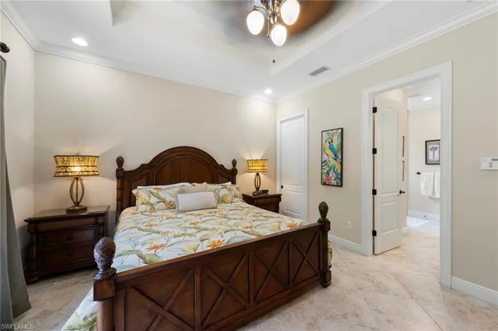 Recessed lighting illuminates a tray ceiling with crown molding