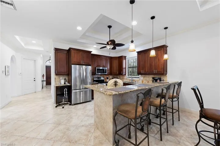 Kitchen featuring rich wood cabinetry, stainless steel appliances, and a tiled backsplash