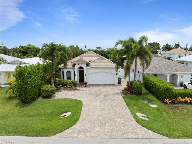 Mediterranean-style residence featuring a tile roof, arched entry, and a paver driveway