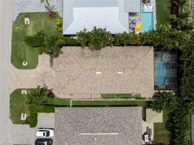 Shingle roof residence featuring a screened-in swimming pool and spa