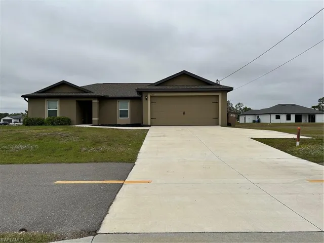 Single story home featuring a garage and a front yard