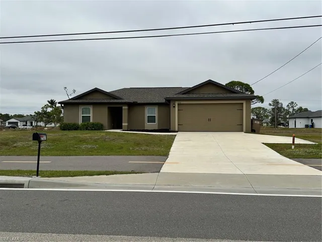 View of front of property featuring a front yard and a garage